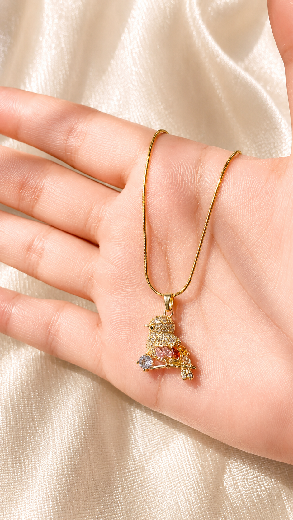 Luxury gold bird pendant necklace with sparkling crystal accents on an elegant gold chain by Jewel Minimals.