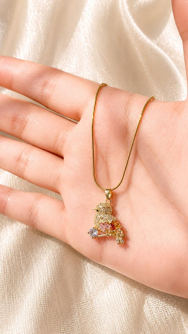 Luxury gold bird pendant necklace with sparkling crystal accents on an elegant gold chain by Jewel Minimals.