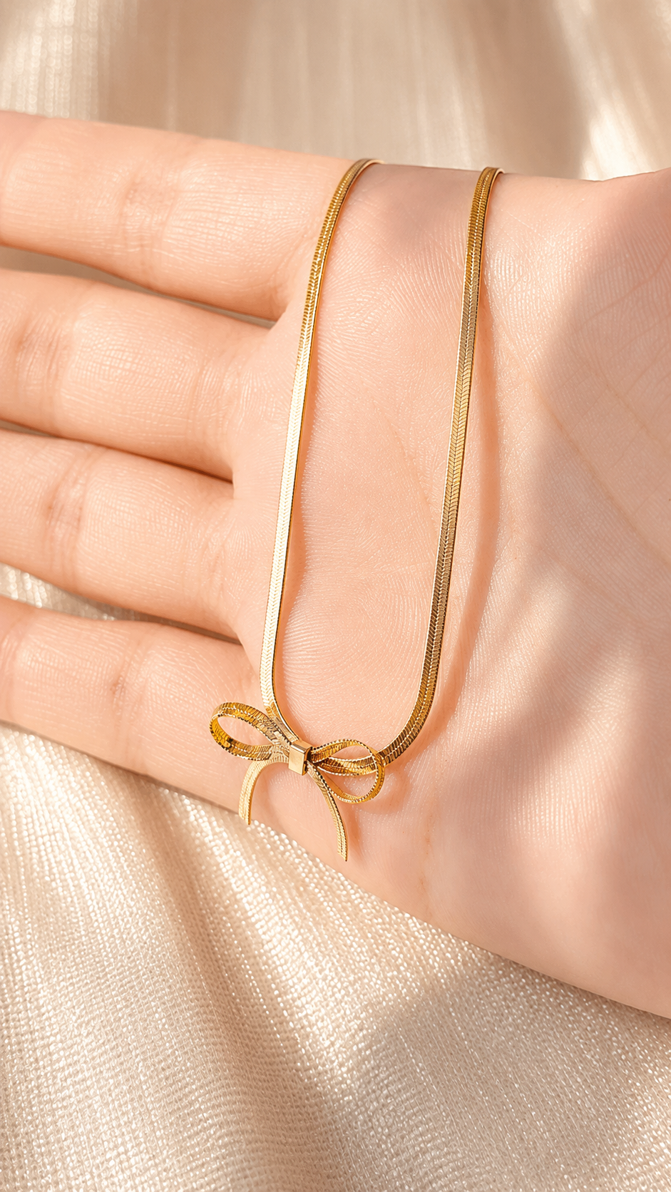 Minimalist gold bow pendant necklace with a premium snake chain and anti-tarnish finish by Jewel Minimals.
