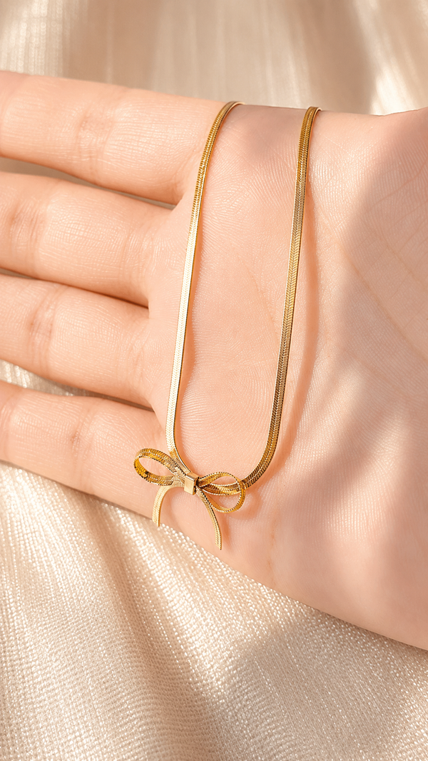 Minimalist gold bow pendant necklace with a premium snake chain and anti-tarnish finish by Jewel Minimals.
