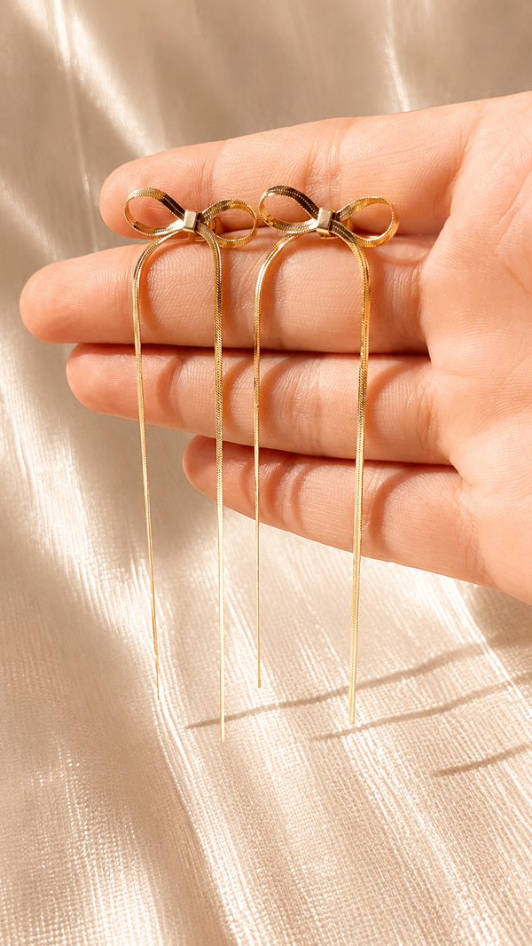 Minimalist gold bow threader earrings with long chain tassels and anti-tarnish finish by Jewel Minimals.