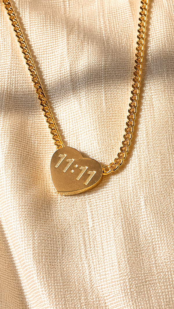Gold heart pendant necklace engraved with 11:11 on a premium Cuban chain with an anti-tarnish finish by Jewel Minimals.
